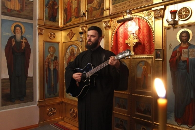 U svešteničkoj mantiji vernicima svira gitaru